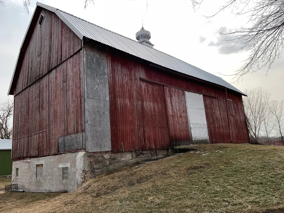 The barn before painting, red paint worn down to gray boards