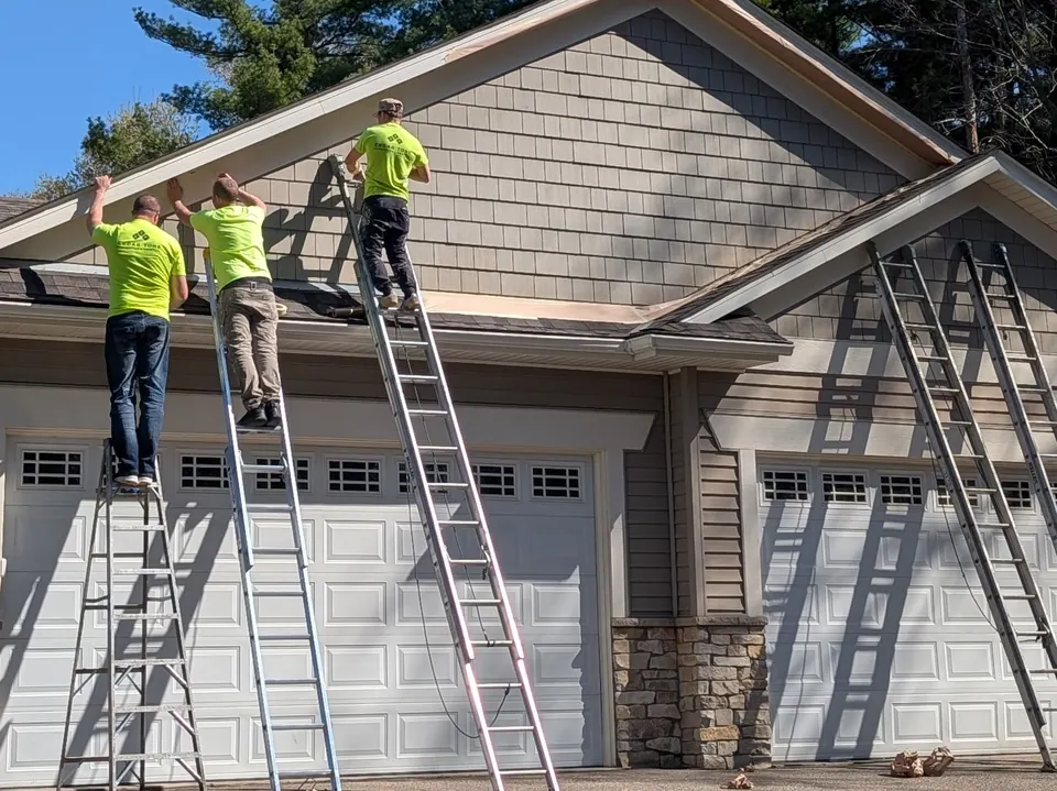 Three Cedar Tone painters on ladders painting the fascia above a garage